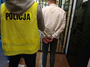 zatrzymany mężczyzna prowadzony przez policjanta do aresztu