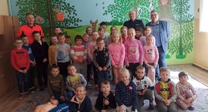 zdjęcie grupowe dzieci z policjantem ratownikiem i dyrektorem szkoły