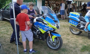 policjant pokazuje dwóm chłopcom policyjne motocykle