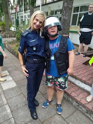 stojąca policjantka obok chłopca, który ma na głowie policyjny kask