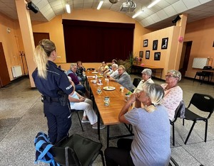 policjanta z seniorami na spotkaniu