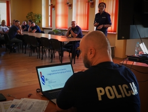 zdjęcie ekranu komputera i policjantem siedzącym za biurkiem
