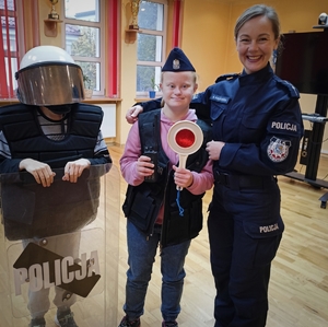 policjantka z dziećmi i sprzętem policyjnym