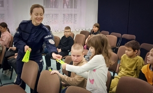policjantka wręcza odblaski dzieciom