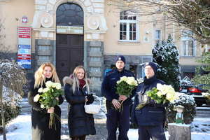 policjanci i inne osoby pod urzędem miasta z kwiatami