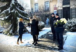 policjanci i inne osoby pod urzędem miasta z kwiatami